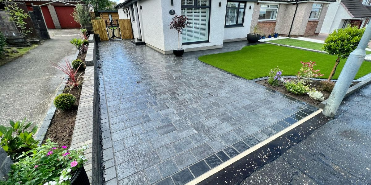 Charcoal block paved driveway with artificial lawn and planting
